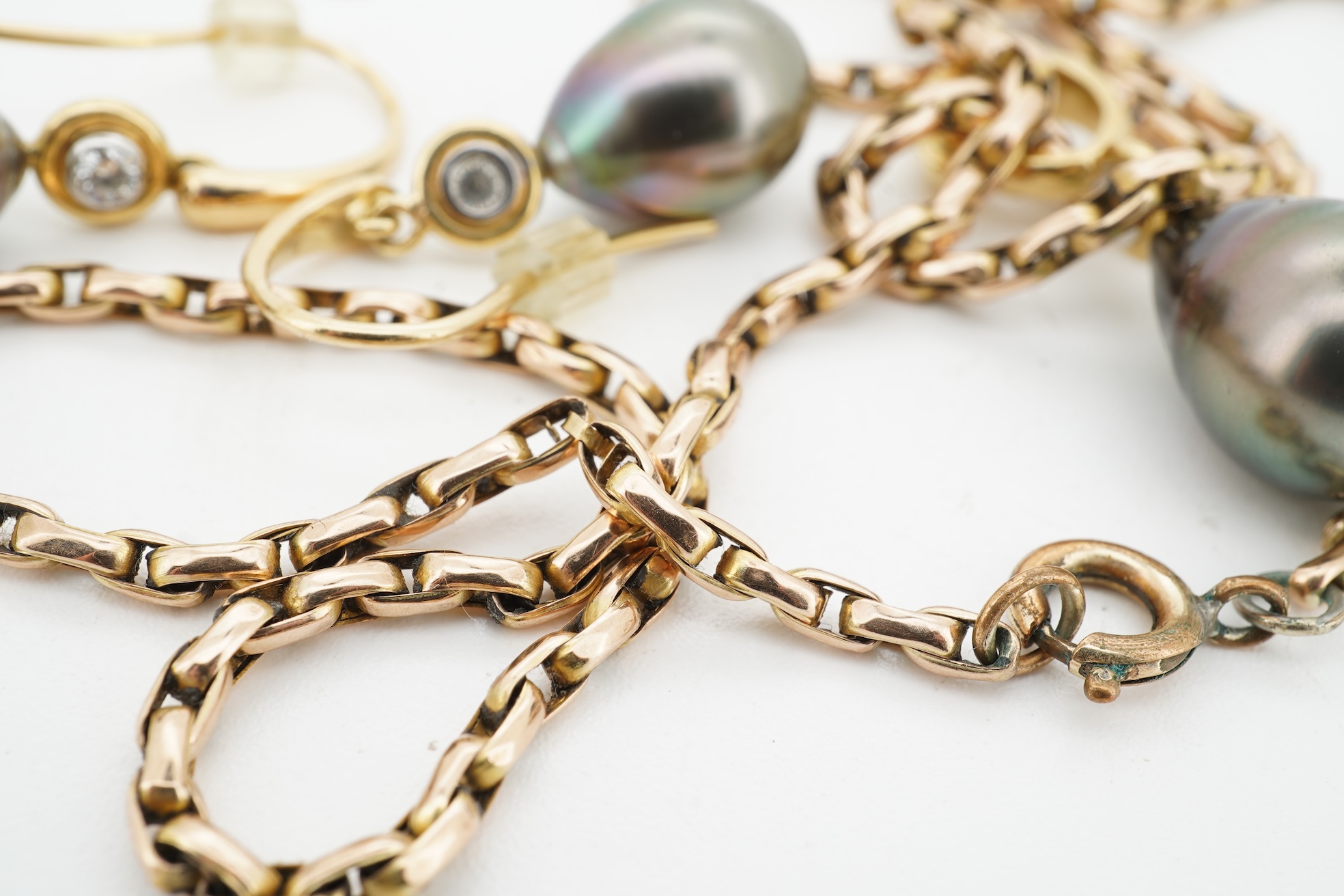 A cultured pearl and diamond demi-parure, comprising: a pendant, suspending a drop-shaped cultured pearl of black tint, measuring approximately 15 x 10.5 x 10.5mm, surmounted by a collet-set brilliant-cut diamond weighin